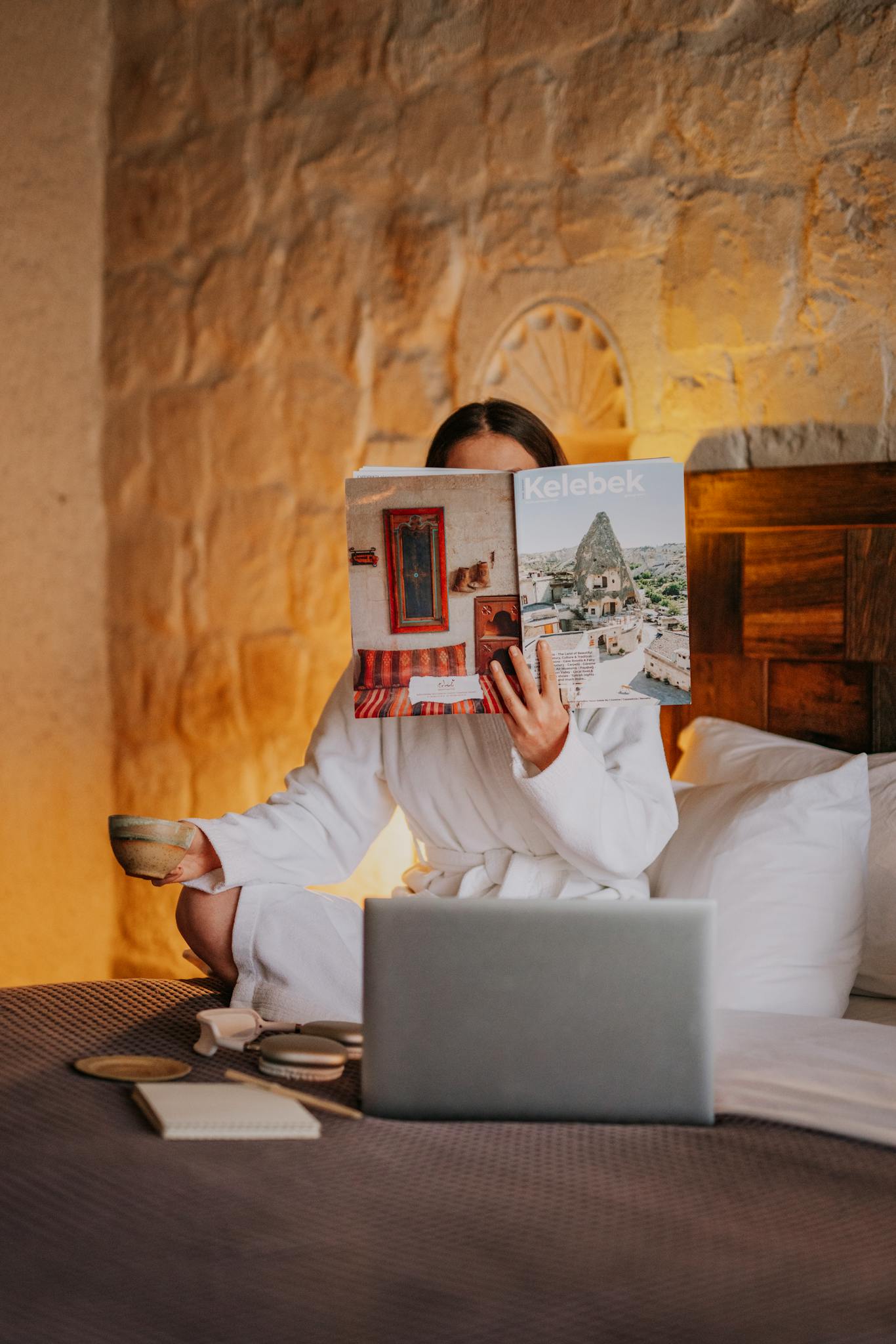 A woman enjoys a serene morning in a Cappadocia hotel, reading and relaxing.