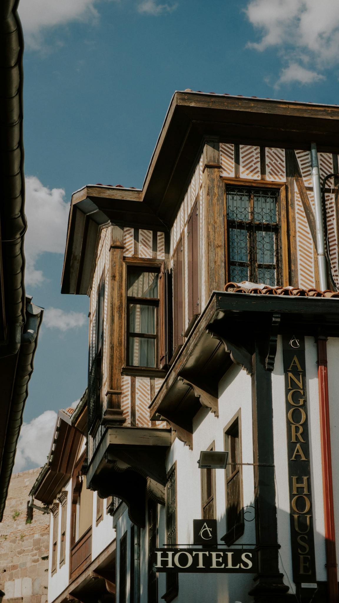 Charming exterior of Angora House with classic architectural details, under a bright blue sky.