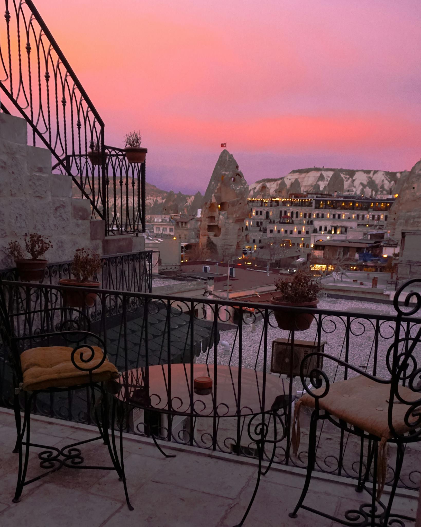 Scenic patio overlooking Cappadocia's unique landscape at sunset.